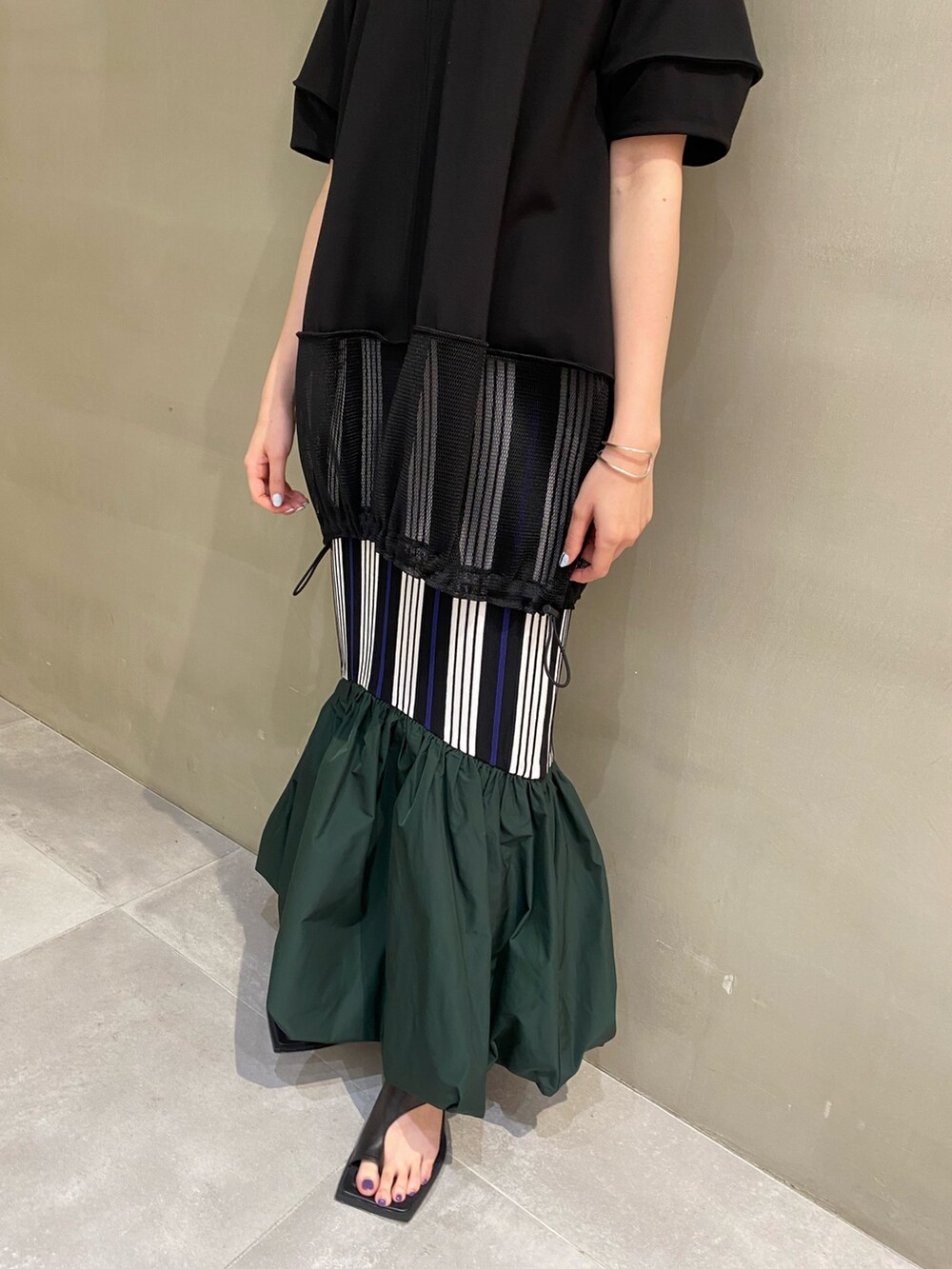 ブラック系のTシャツ/カットソー、ブラック系のサンダル、その他のスカートを着用したレディースの春コーディネートの6枚目の写真