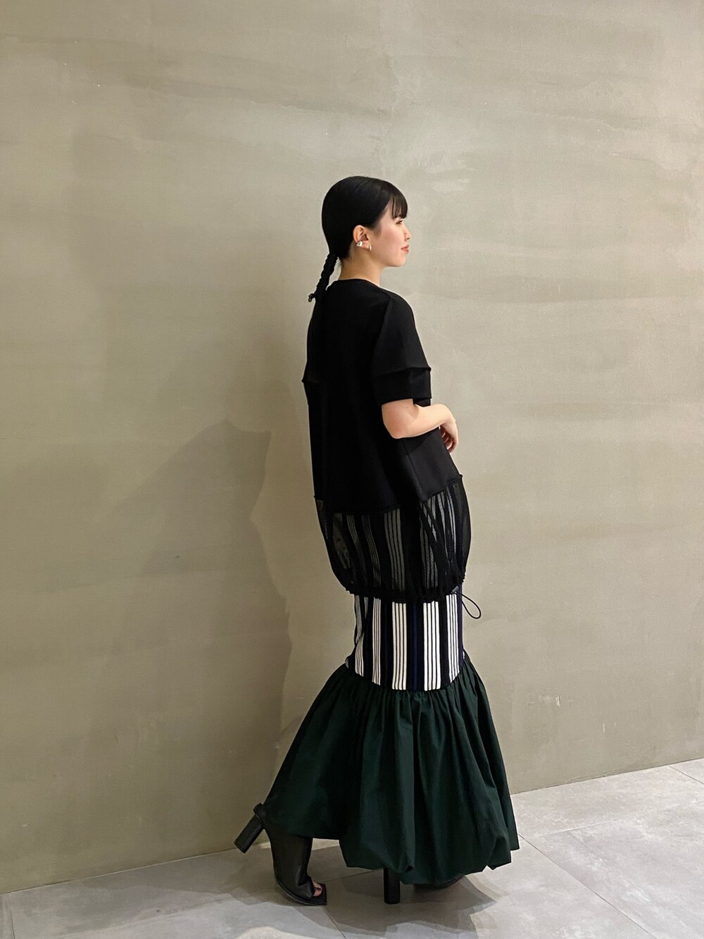 ブラック系のTシャツ/カットソー、ブラック系のサンダル、その他のスカートを着用したレディースの春コーディネートの2枚目の写真