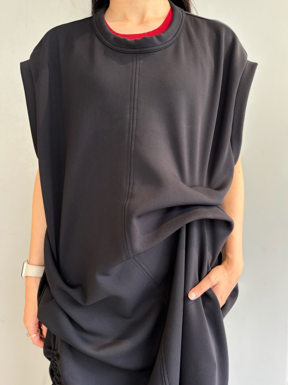 レッド系のタンクトップ、ブラック系のワンピース、シルバー系のイヤリングを着用したレディースの夏コーディネートの6枚目の写真