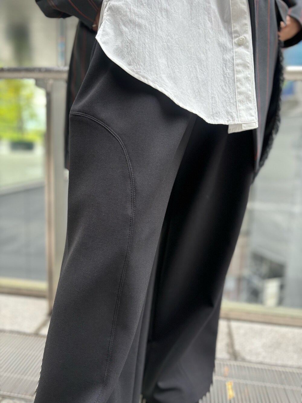 グレー系のテーラードジャケット、オレンジ系のニット/セーター、ホワイト系のシャツ/ブラウスを着用したレディースの夏コーディネートの8枚目の写真