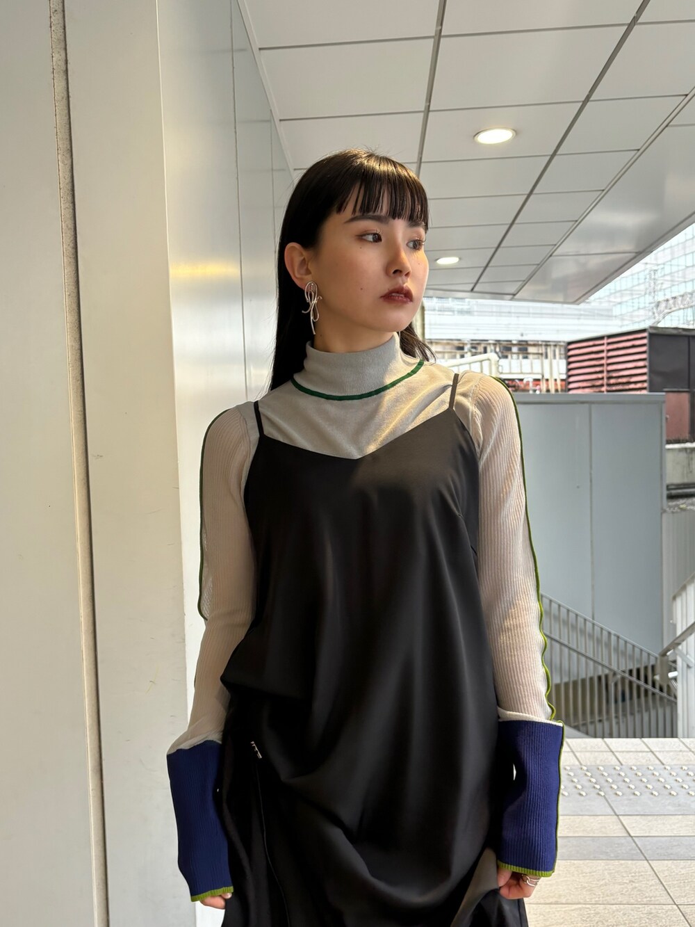 グレー系のニット/セーター、ブラック系のワンピース、シルバー系のパンプスを着用したレディースの春コーディネートの4枚目の写真