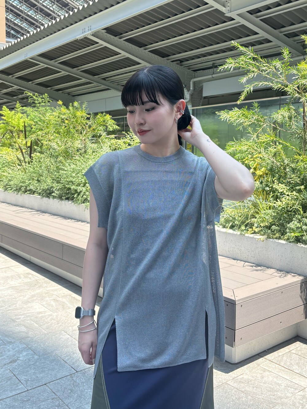 グレー系のニット/セーター、ブラック系のキャミソール、グリーン系のスカートを着用したレディースの夏コーディネートの4枚目の写真