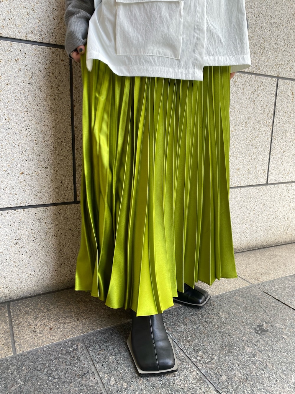 グレー系のニット/セーター、ブラック系のブーツ、グリーン系のスカートを着用したレディースの冬コーディネートの9枚目の写真