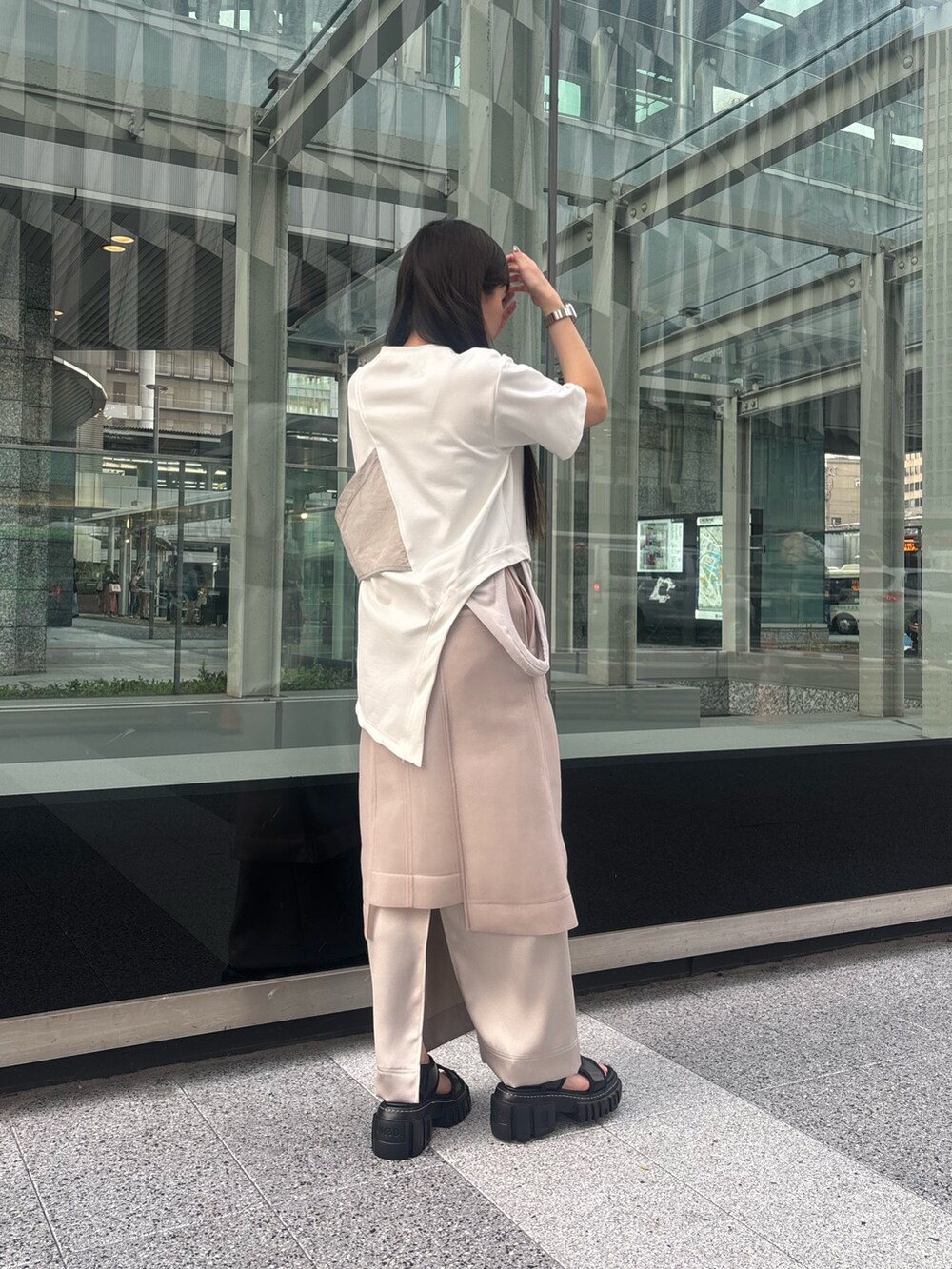 ホワイト系のTシャツ/カットソー、ベージュ系のスカート、ブラック系のサンダルを着用したレディースの春コーディネートの3枚目の写真