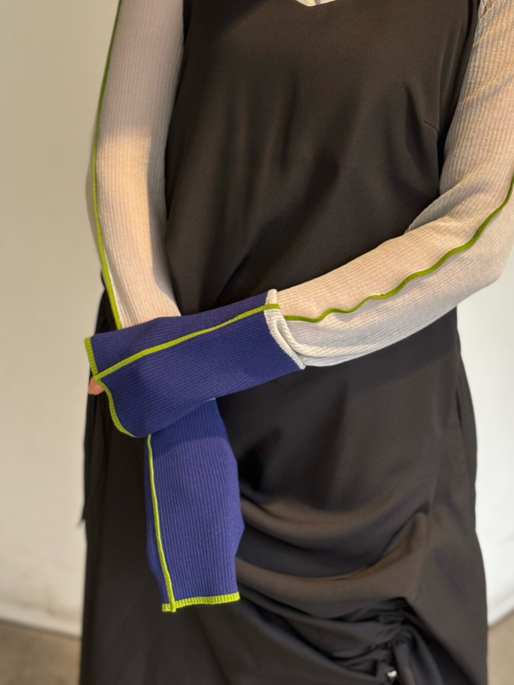 グレー系のニット/セーター、ブラック系のワンピース、シルバー系のパンプスを着用したレディースの春コーディネートの7枚目の写真