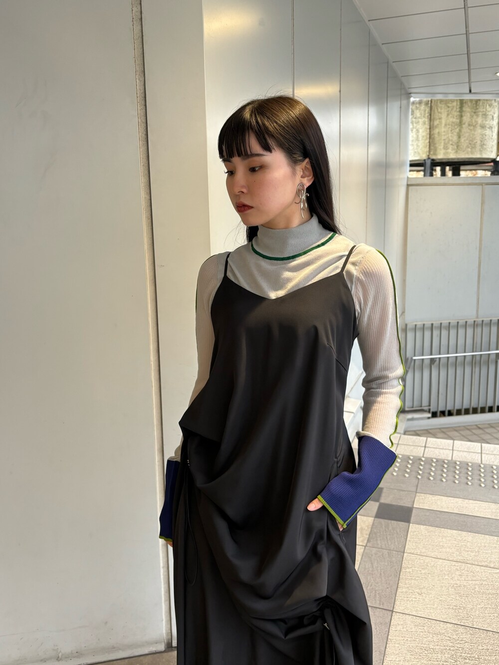 グレー系のニット/セーター、ブラック系のワンピース、シルバー系のパンプスを着用したレディースの春コーディネートの5枚目の写真