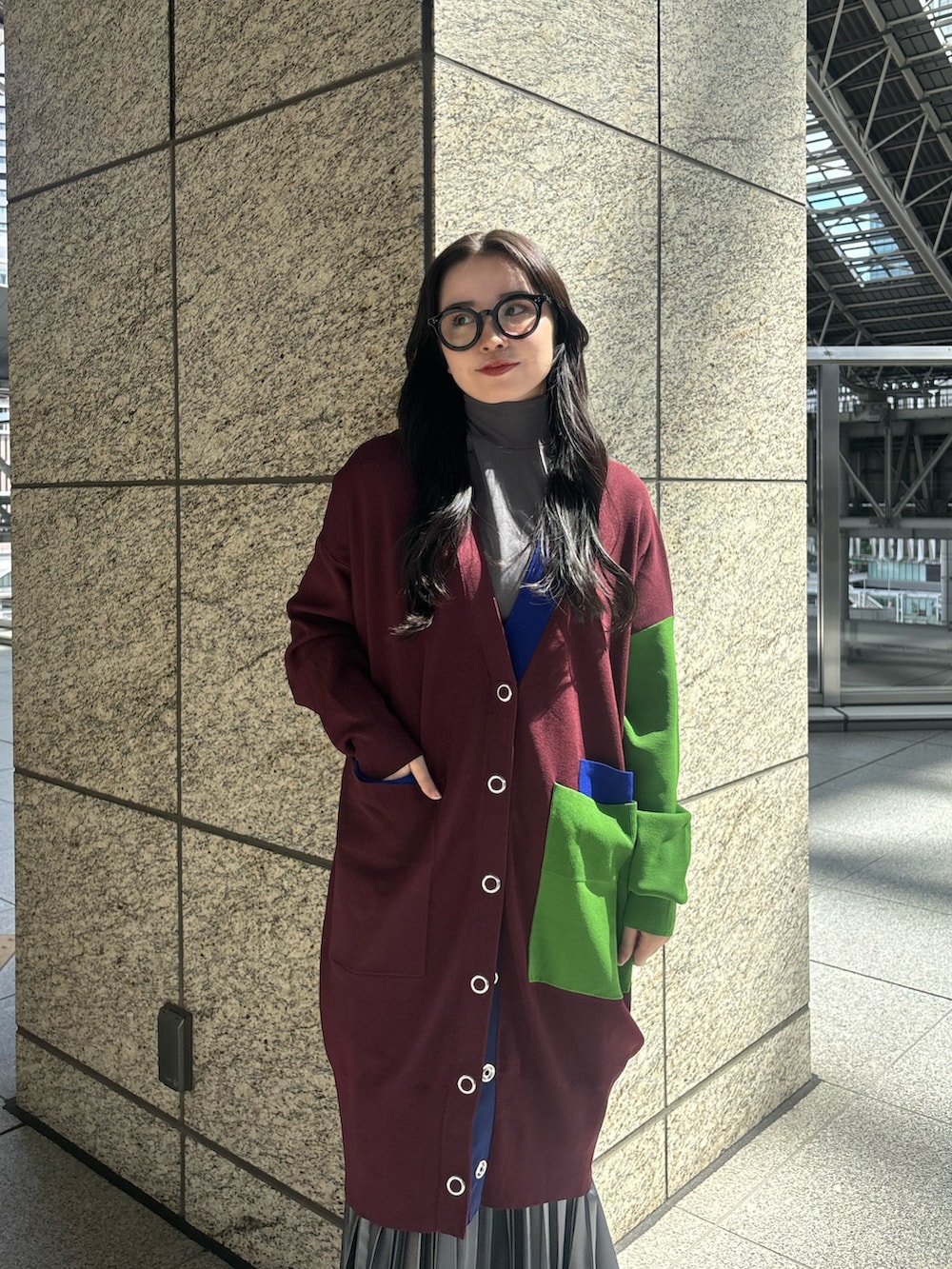 グレー系のTシャツ/カットソー、ブラウン系のカーディガン/ボレロ、グレー系のスカートを着用したレディースの秋コーディネートの6枚目の写真