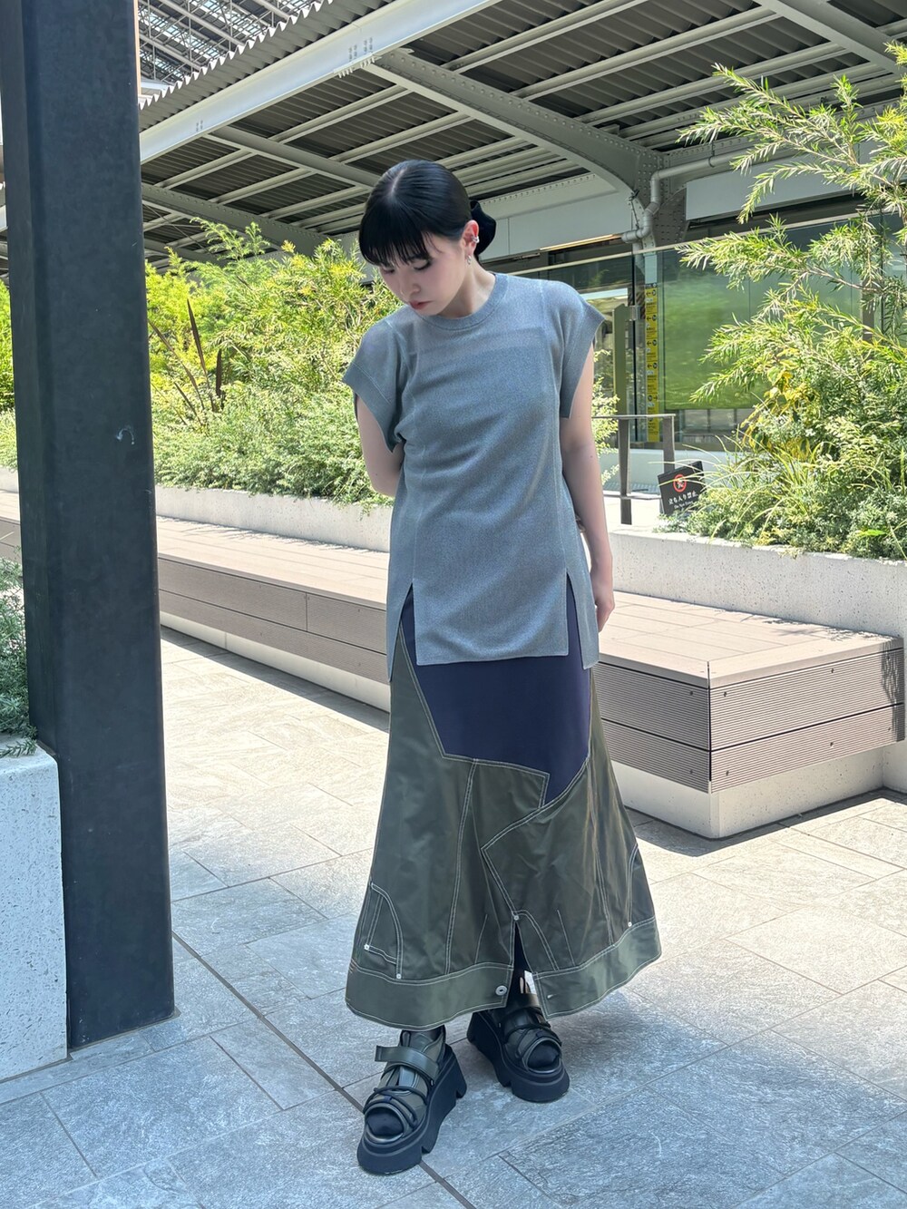 グレー系のニット/セーター、ブラック系のキャミソール、グリーン系のスカートを着用したレディースの夏コーディネートの2枚目の写真