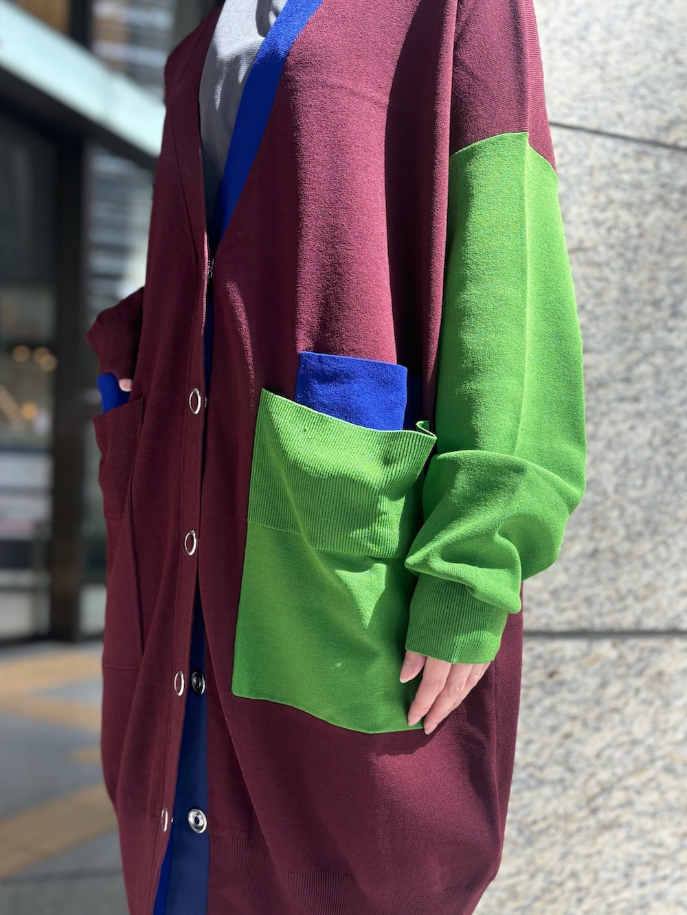 グレー系のTシャツ/カットソー、ブラウン系のカーディガン/ボレロ、グレー系のスカートを着用したレディースの秋コーディネートの7枚目の写真