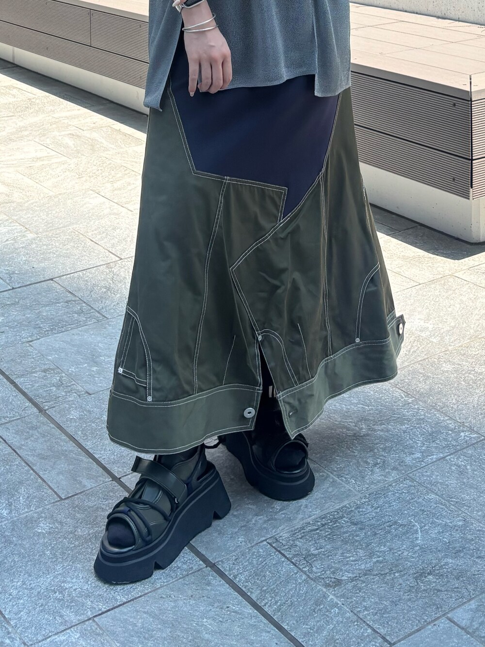 グレー系のニット/セーター、ブラック系のキャミソール、グリーン系のスカートを着用したレディースの夏コーディネートの6枚目の写真