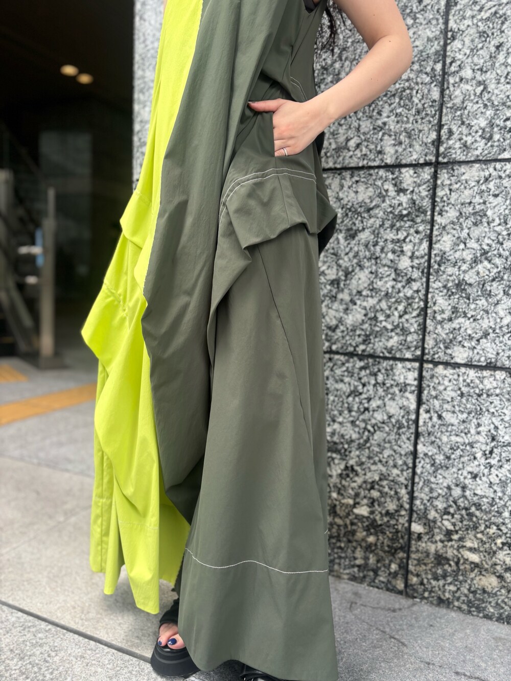 グリーン系のワンピース、ブラック系のサンダルを着用したレディースの春コーディネートの7枚目の写真