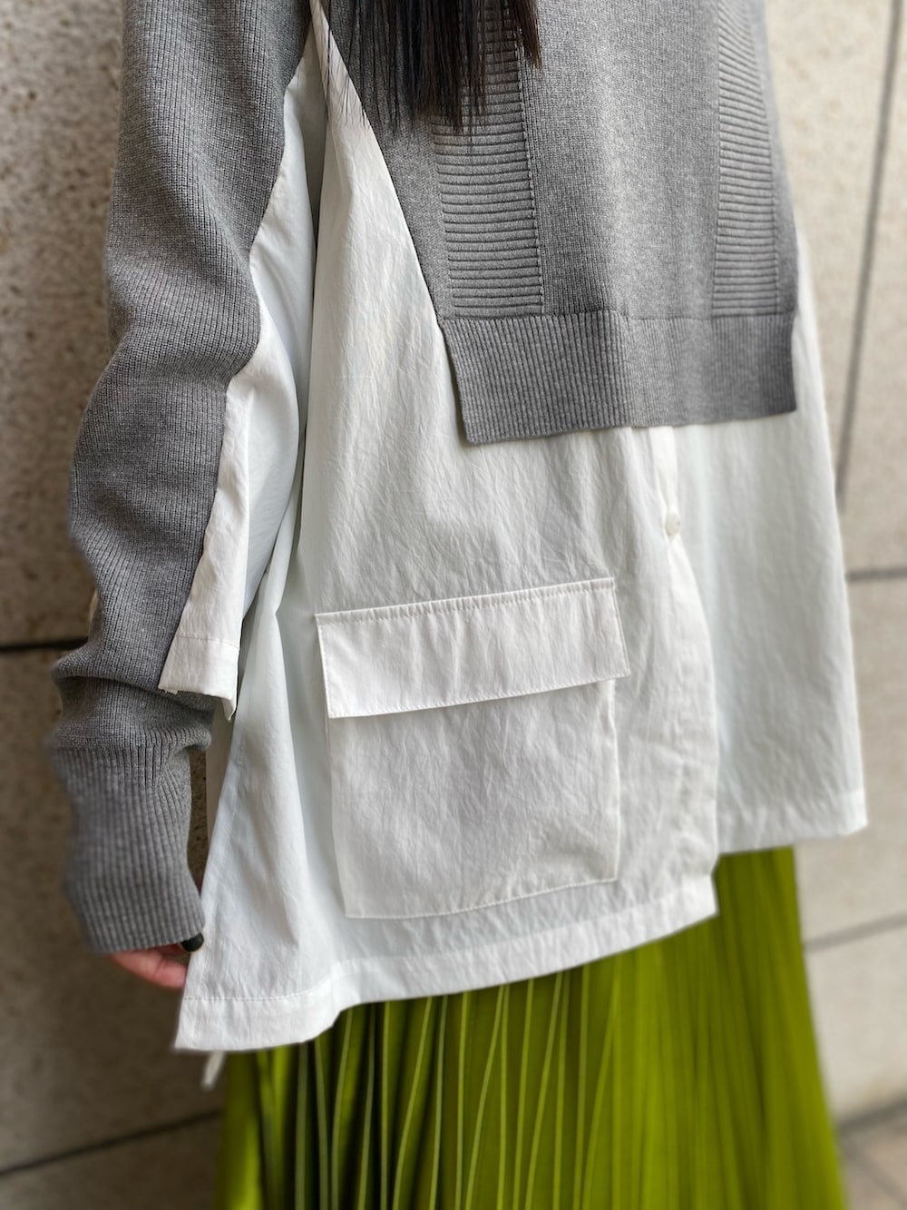 グレー系のニット/セーター、ブラック系のブーツ、グリーン系のスカートを着用したレディースの冬コーディネートの8枚目の写真