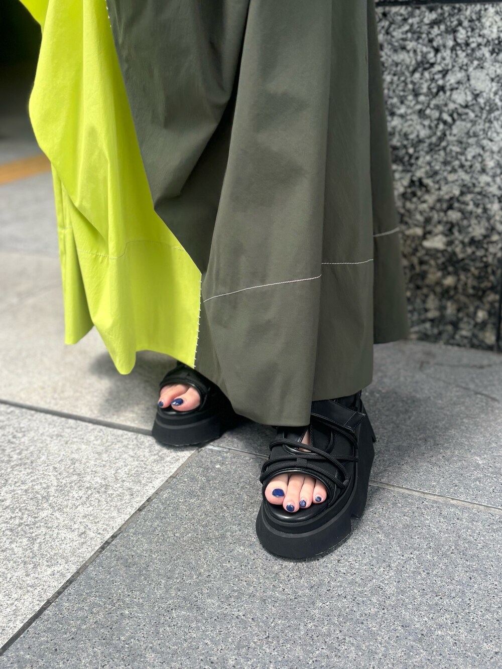 グリーン系のワンピース、ブラック系のサンダルを着用したレディースの春コーディネートの8枚目の写真