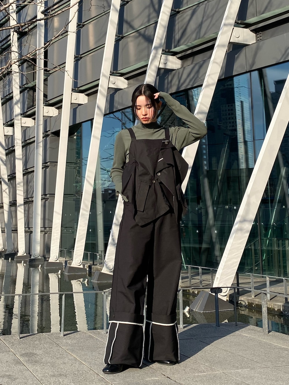 ブラック系のその他パンツ、ブラック系のキャミソール、グリーン系のニット/セーターを着用したレディースの冬コーディネートの3枚目の写真