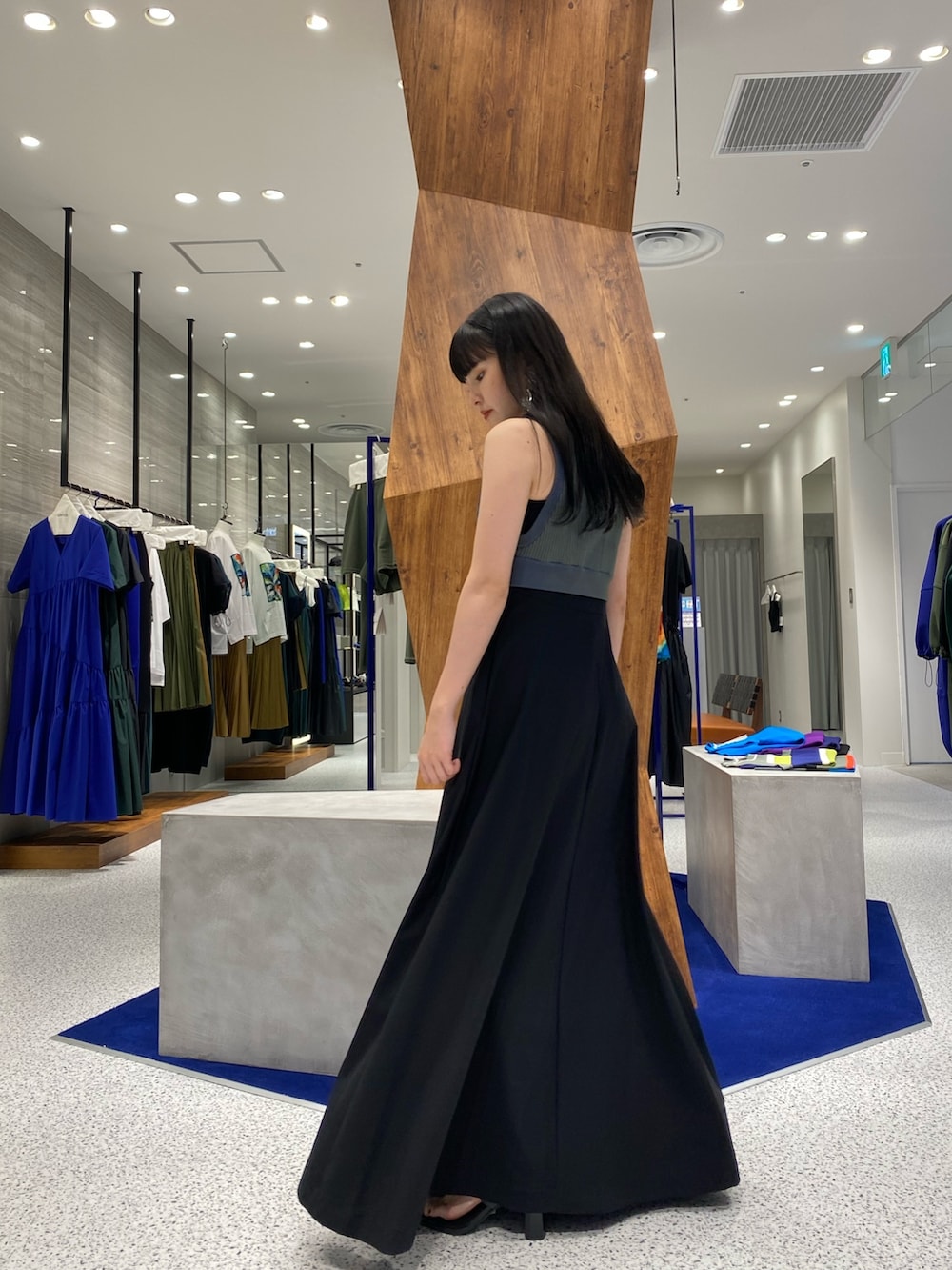 ブラック系のワンピース、グリーン系のタンクトップ、ブラック系のサンダルを着用したレディースの夏コーディネートの5枚目の写真