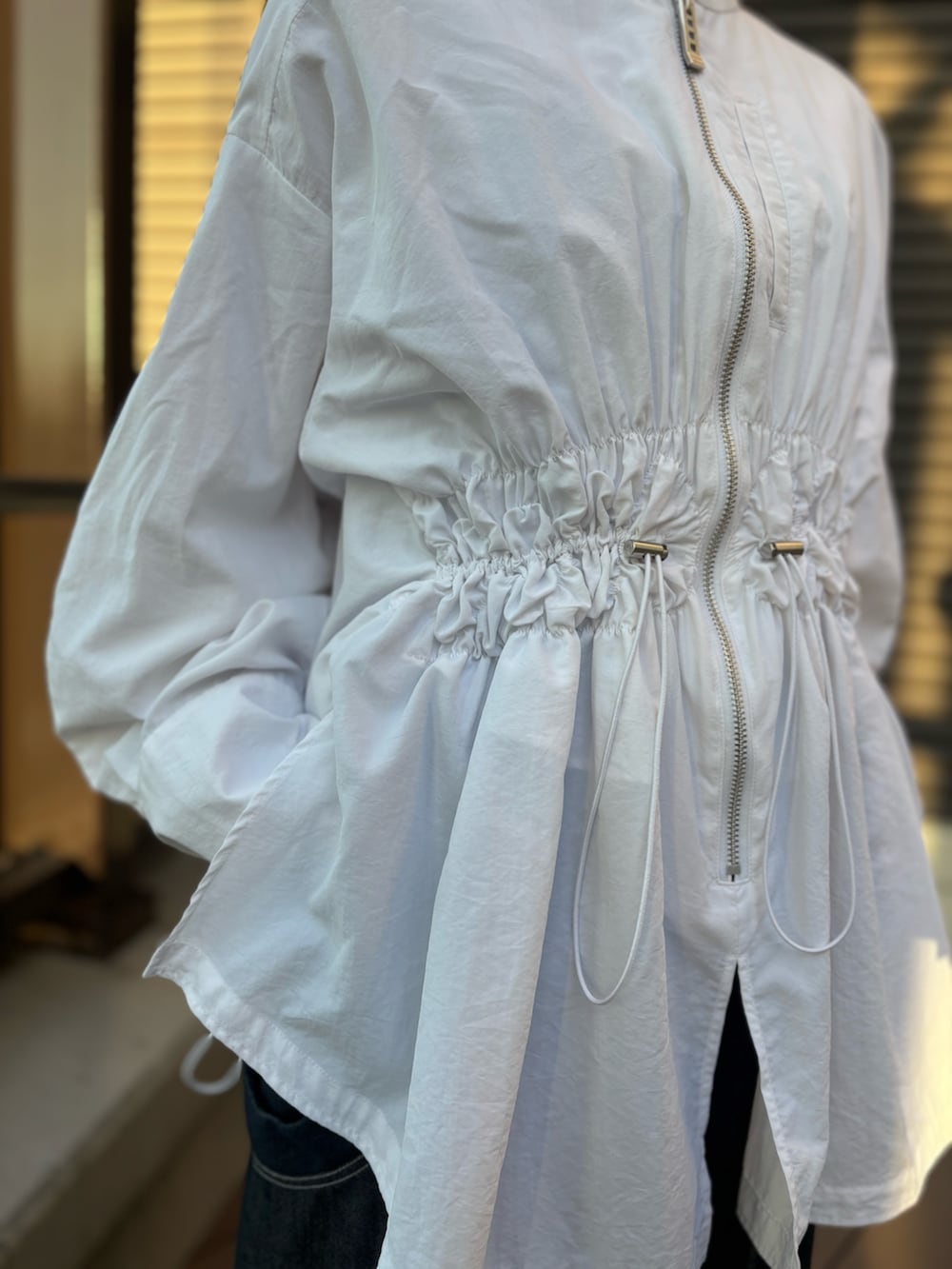 ホワイト系のシャツ/ブラウス、ブルー系のその他パンツ、ベージュ系のブーツを着用したレディースの春コーディネートの7枚目の写真