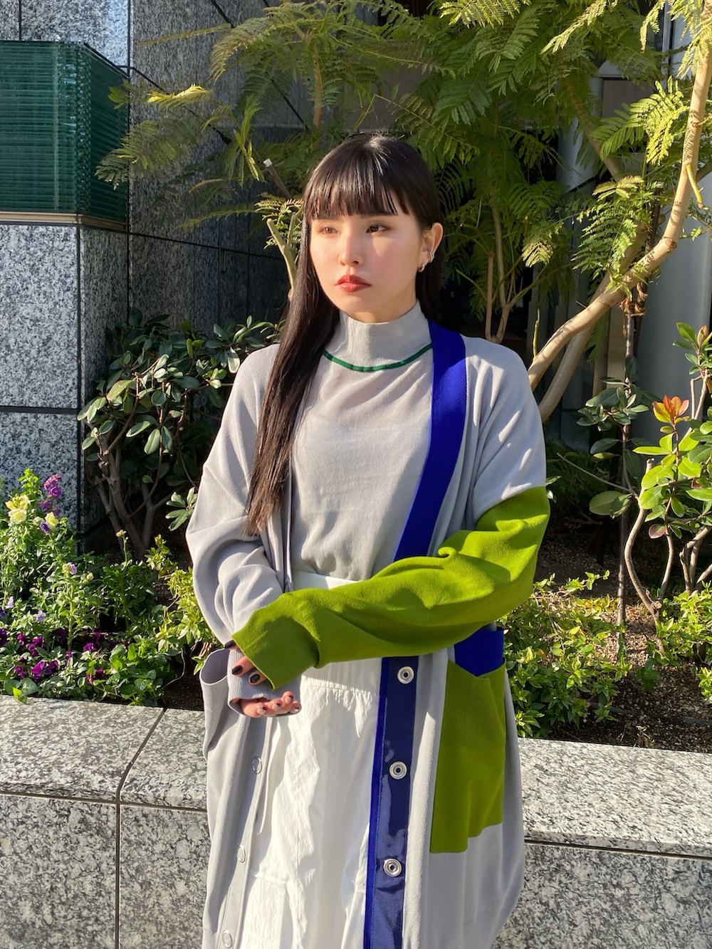 グレー系のニット/セーター、グレー系のカーディガン/ボレロ、ホワイト系のスカートを着用したレディースの冬コーディネートの8枚目の写真