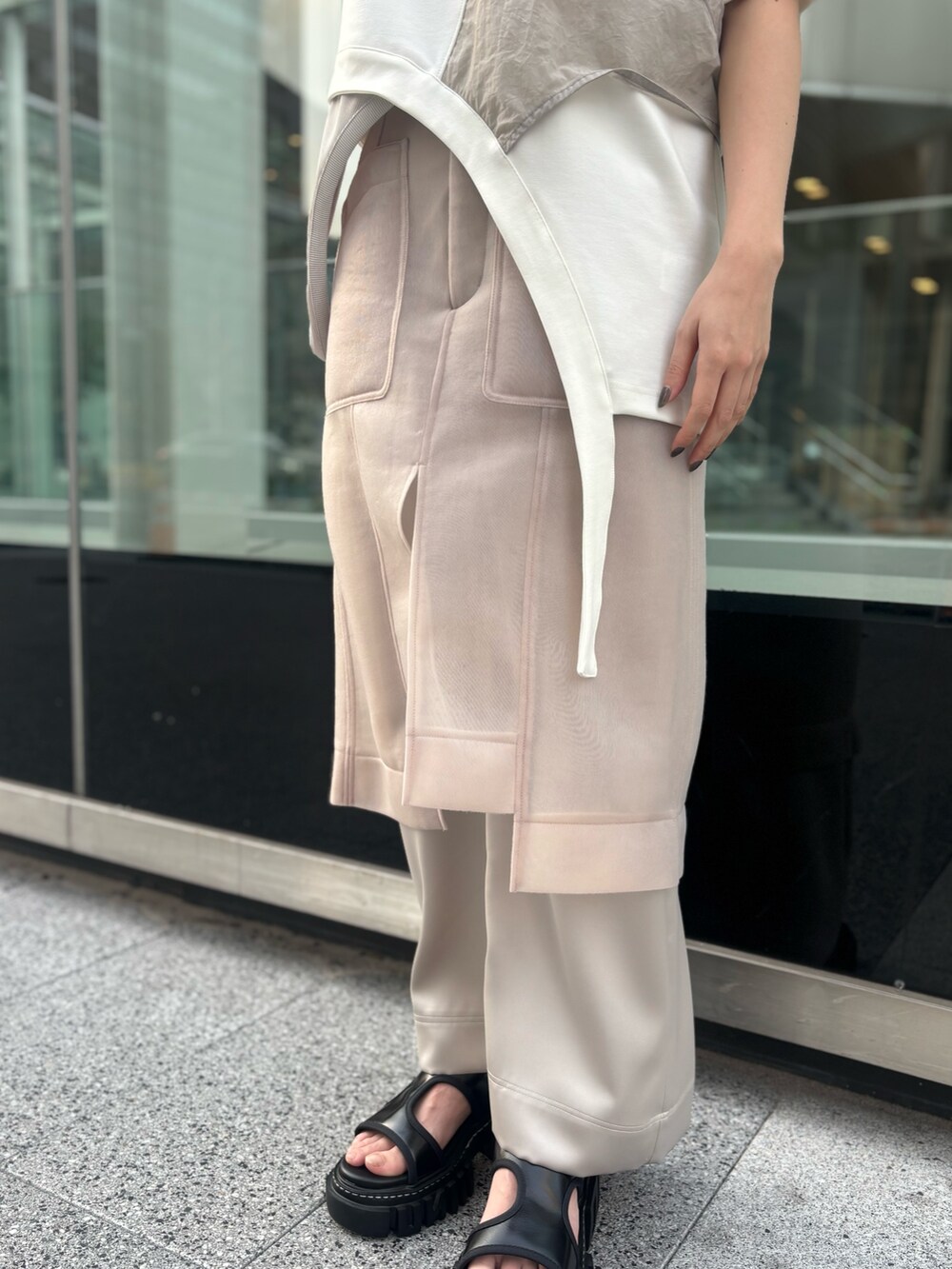 ホワイト系のTシャツ/カットソー、ベージュ系のスカート、ブラック系のサンダルを着用したレディースの春コーディネートの8枚目の写真