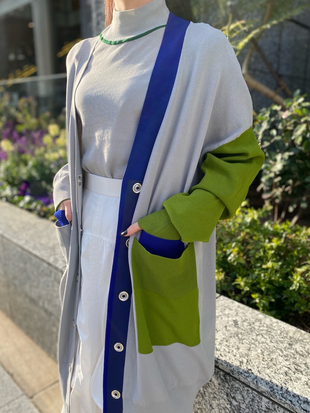 グレー系のニット/セーター、グレー系のカーディガン/ボレロ、ホワイト系のスカートを着用したレディースの冬コーディネートの5枚目の写真