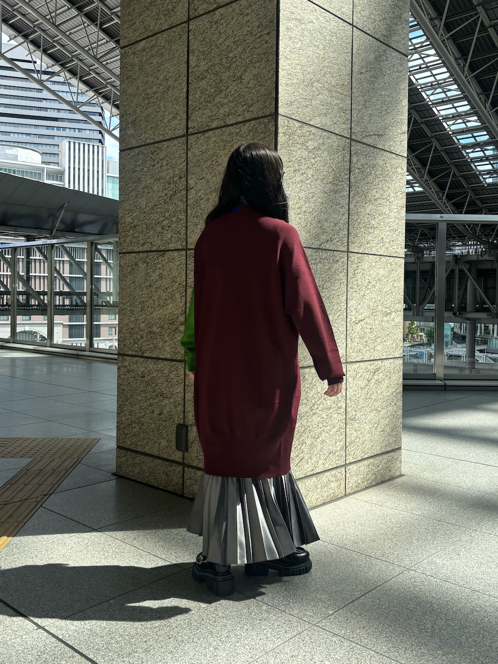 グレー系のTシャツ/カットソー、ブラウン系のカーディガン/ボレロ、グレー系のスカートを着用したレディースの秋コーディネートの4枚目の写真