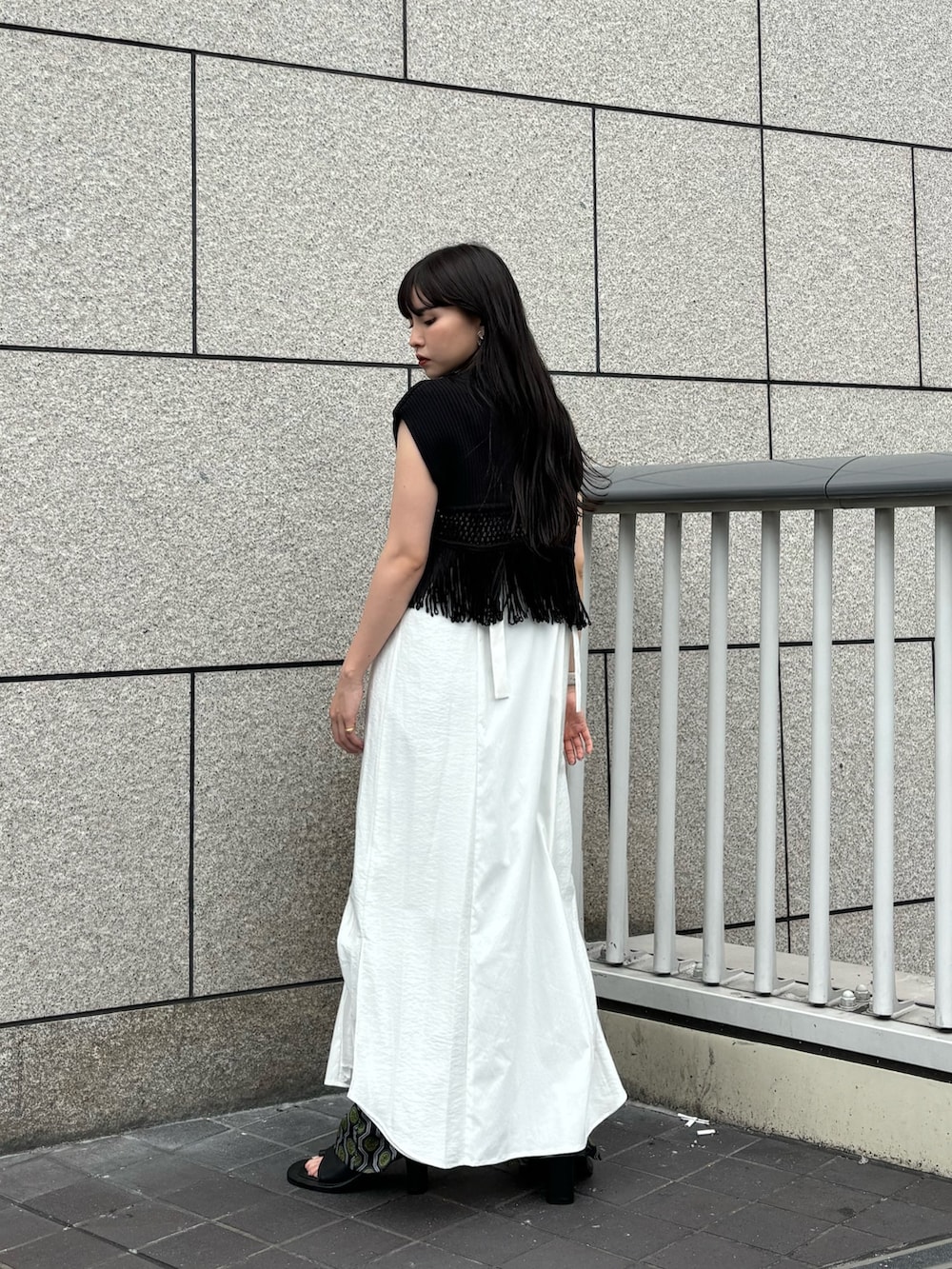 ブラック系のニット/セーター、ホワイト系のワンピース、ブラック系のその他パンツを着用したレディースの夏コーディネートの3枚目の写真