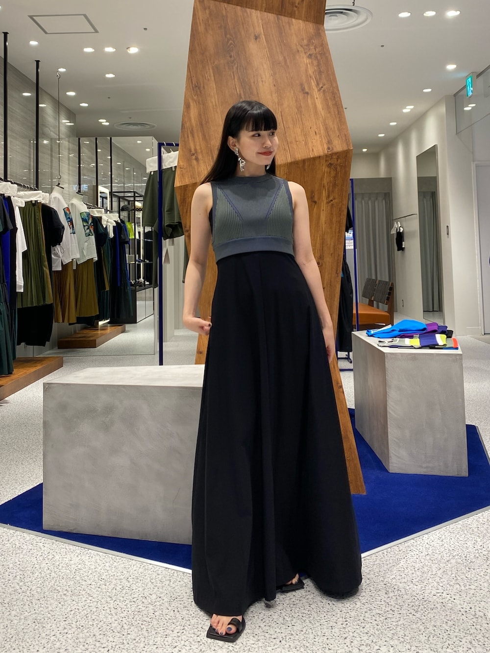 ブラック系のワンピース、グリーン系のタンクトップ、ブラック系のサンダルを着用したレディースの夏コーディネートの2枚目の写真