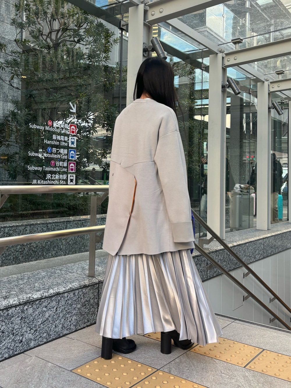 ホワイト系のシャツ/ブラウス、ベージュ系のニット/セーター、シルバー系のスカートを着用したレディースの冬コーディネートの3枚目の写真