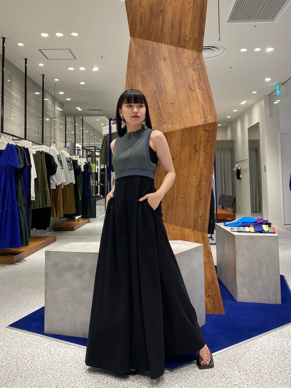 ブラック系のワンピース、グリーン系のタンクトップ、ブラック系のサンダルを着用したレディースの夏コーディネートの3枚目の写真