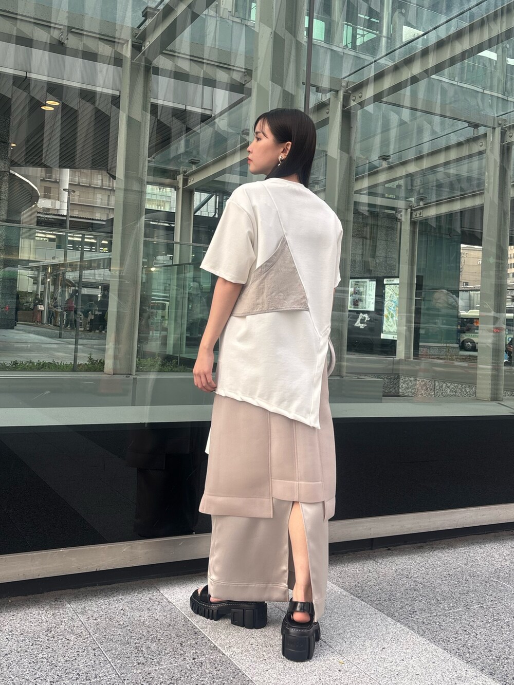 ホワイト系のTシャツ/カットソー、ベージュ系のスカート、ブラック系のサンダルを着用したレディースの春コーディネートの4枚目の写真