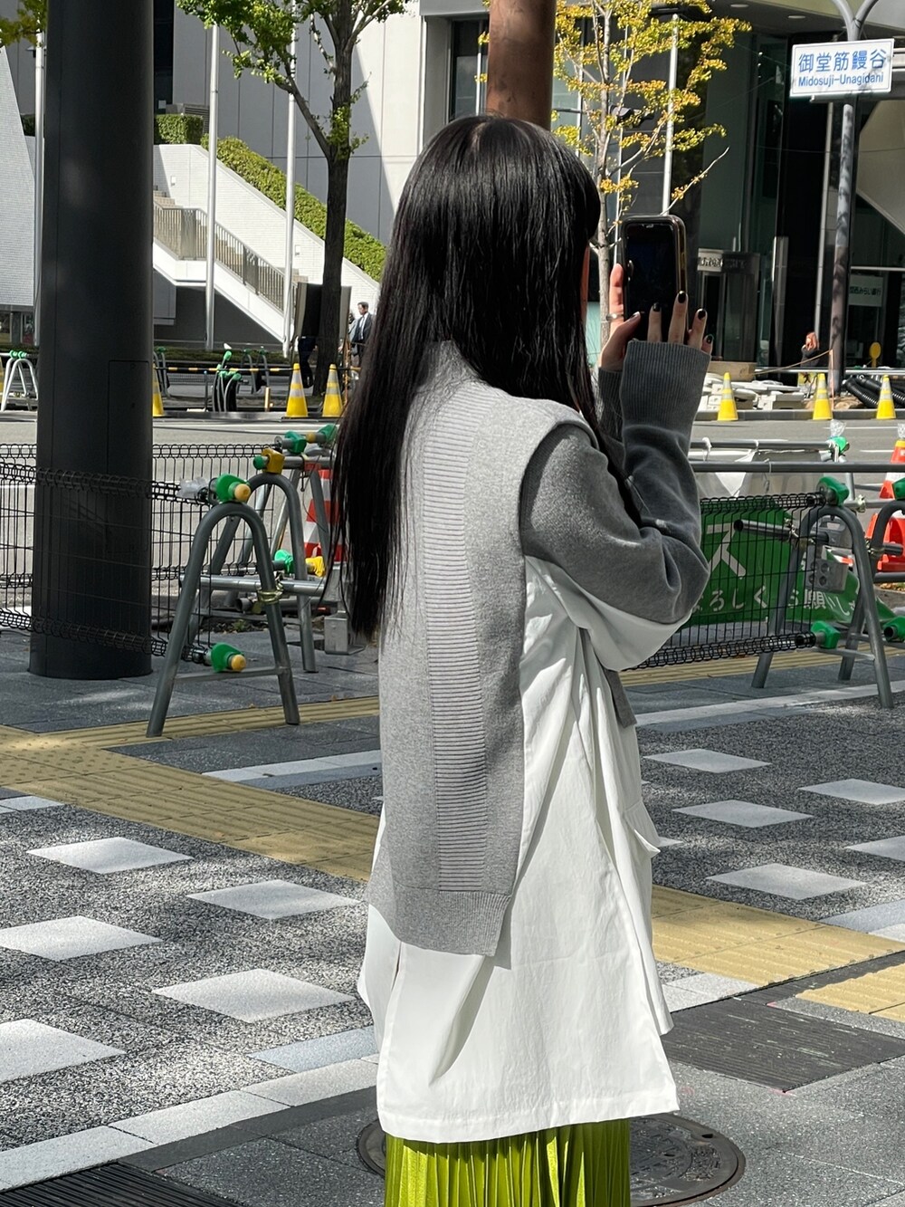 グレー系のニット/セーター、ブラック系のブーツ、グリーン系のスカートを着用したレディースの冬コーディネートの4枚目の写真