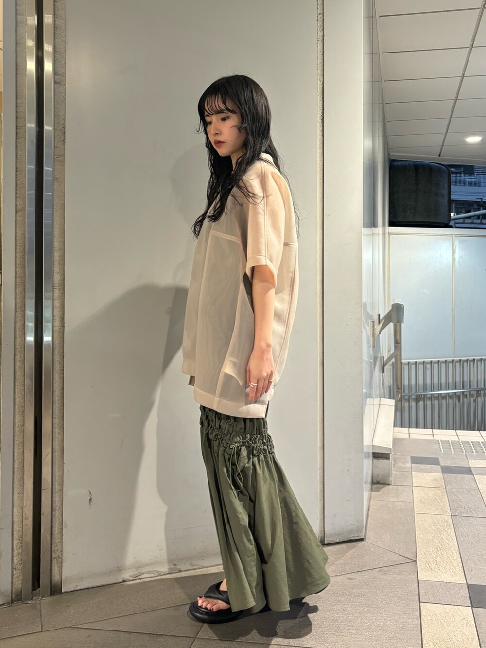 ベージュ系のTシャツ/カットソー、グリーン系のタンクトップ、グリーン系のスカートを着用したレディースの春コーディネートの2枚目の写真