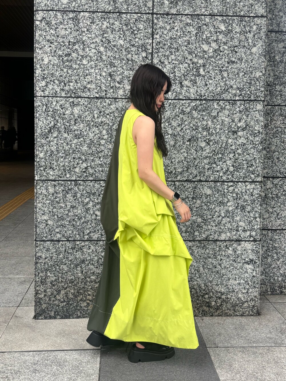 グリーン系のワンピース、ブラック系のサンダルを着用したレディースの春コーディネートの3枚目の写真