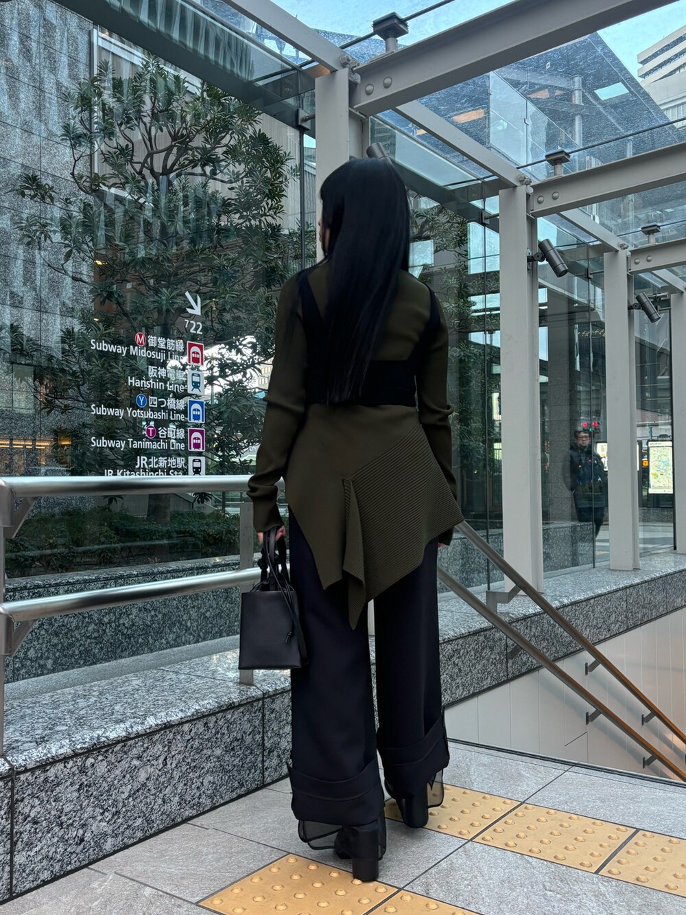 ブラック系のキャミソール、グリーン系のニット/セーター、ブラック系のその他パンツを着用したレディースの冬コーディネートの3枚目の写真