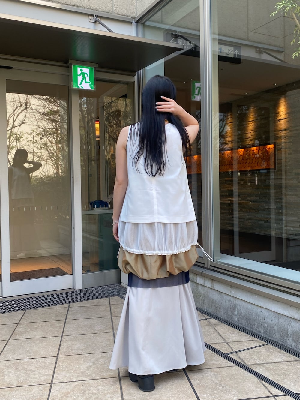 ホワイト系のタンクトップ、イエロー系のスカートを着用したレディースの春コーディネートの4枚目の写真