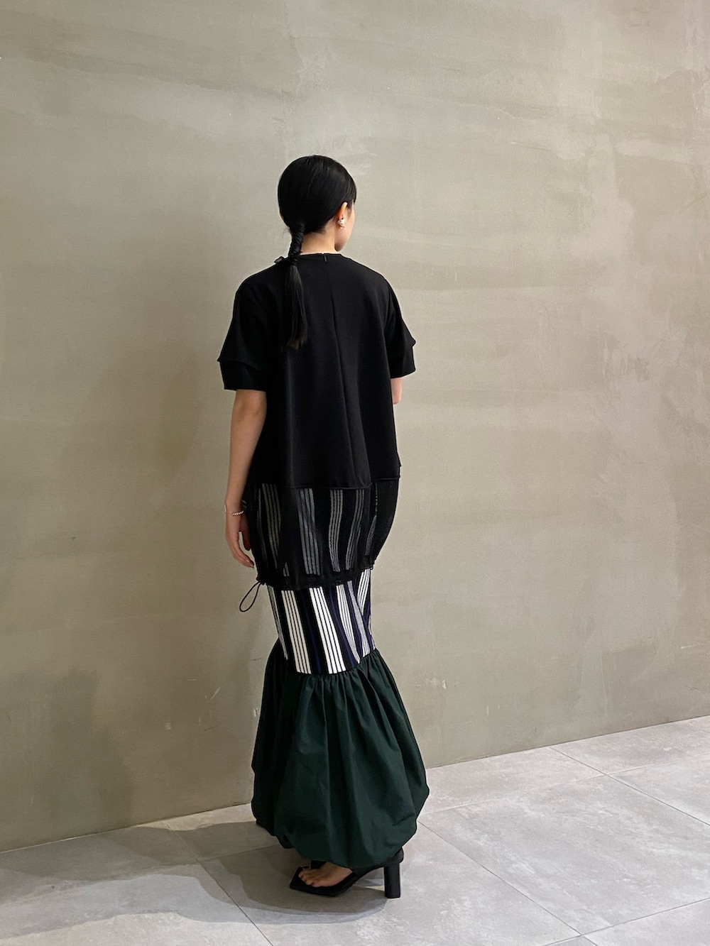 ブラック系のTシャツ/カットソー、ブラック系のサンダル、その他のスカートを着用したレディースの春コーディネートの4枚目の写真