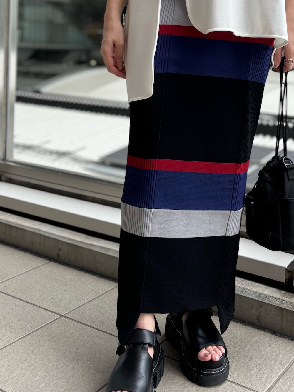 ホワイト系のTシャツ/カットソー、グレー系のスカートを着用したレディースの春コーディネートの7枚目の写真