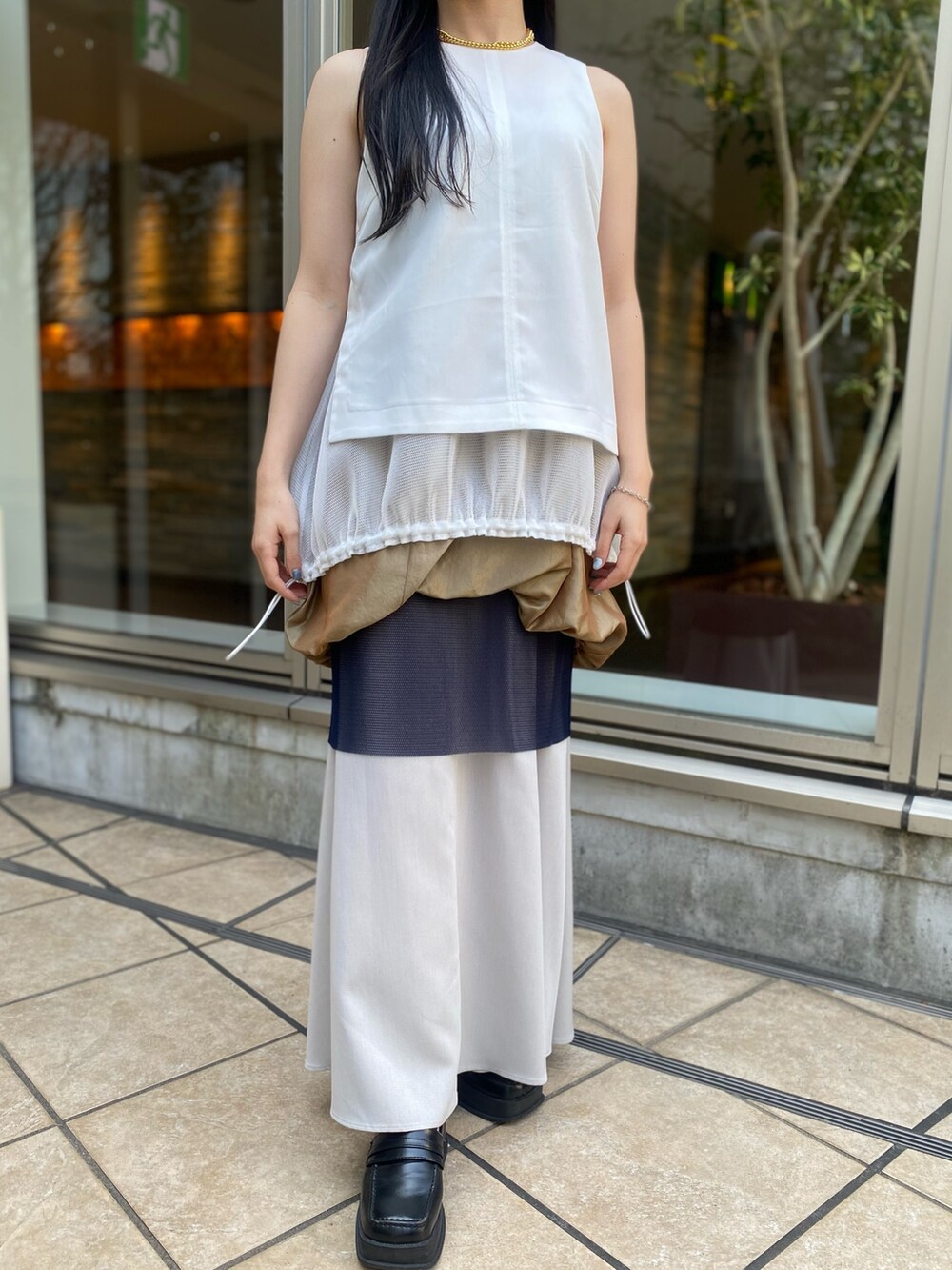 ホワイト系のタンクトップ、イエロー系のスカートを着用したレディースの春コーディネートの7枚目の写真