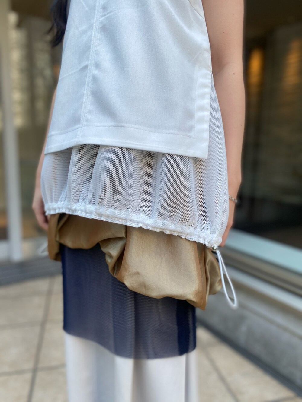 ホワイト系のタンクトップ、イエロー系のスカートを着用したレディースの春コーディネートの6枚目の写真