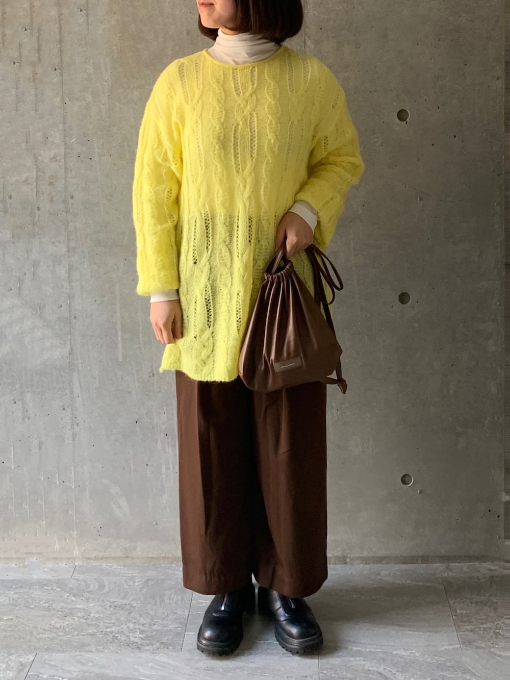 ブラウン系のショルダーバッグ、ブラウン系のその他パンツ、ブラック系のブーツを着用したレディースの冬コーディネートの2枚目の写真