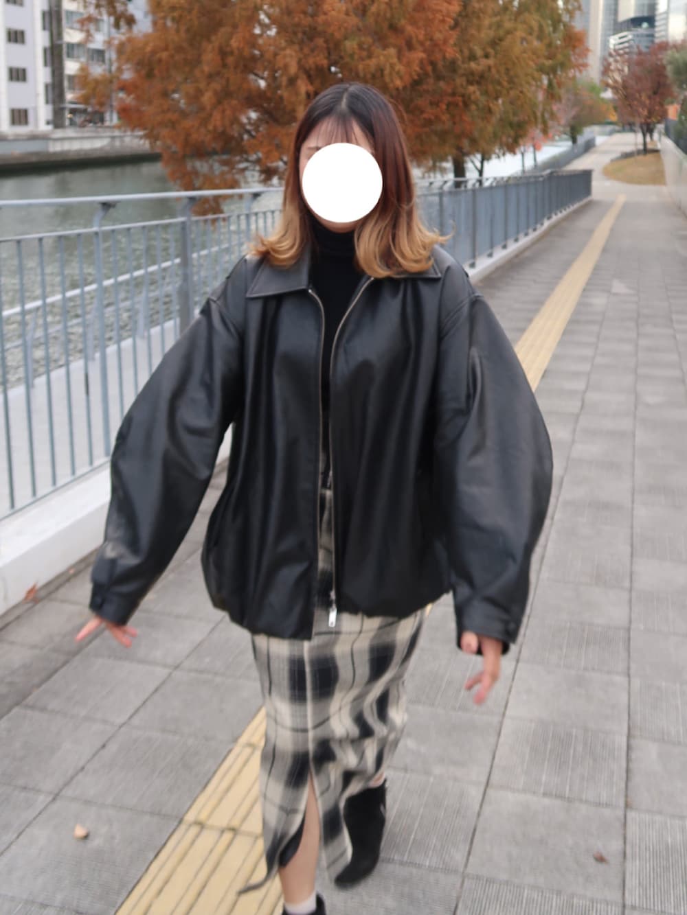 ブラック系のブルゾン、ブラック系のニット/セーター、ベージュ系のスカートを着用したレディースの冬コーディネートの3枚目の写真