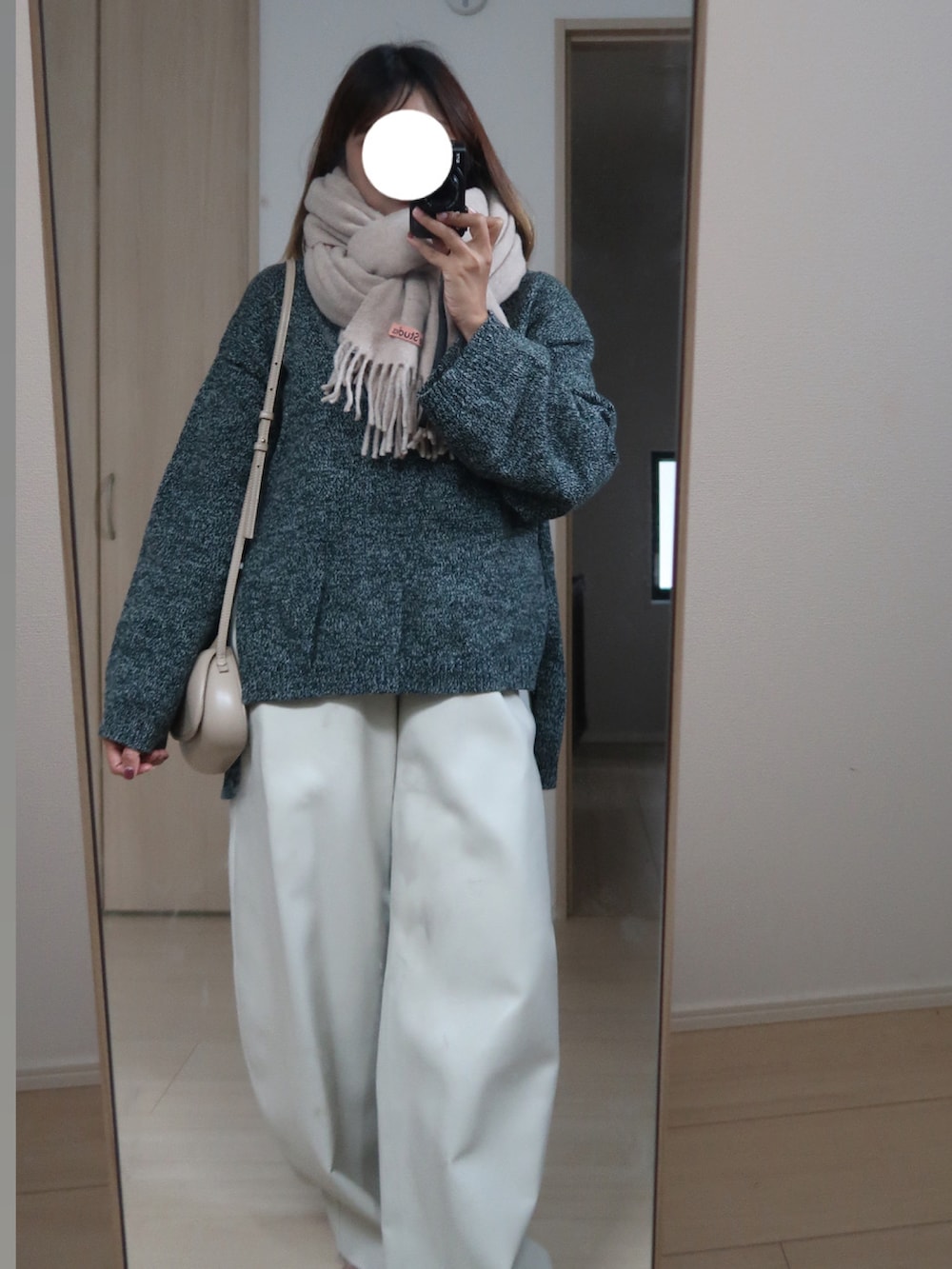 グリーン系のニット/セーター、ベージュ系のバッグ、ホワイト系のその他パンツを着用したレディースの秋コーディネートの2枚目の写真