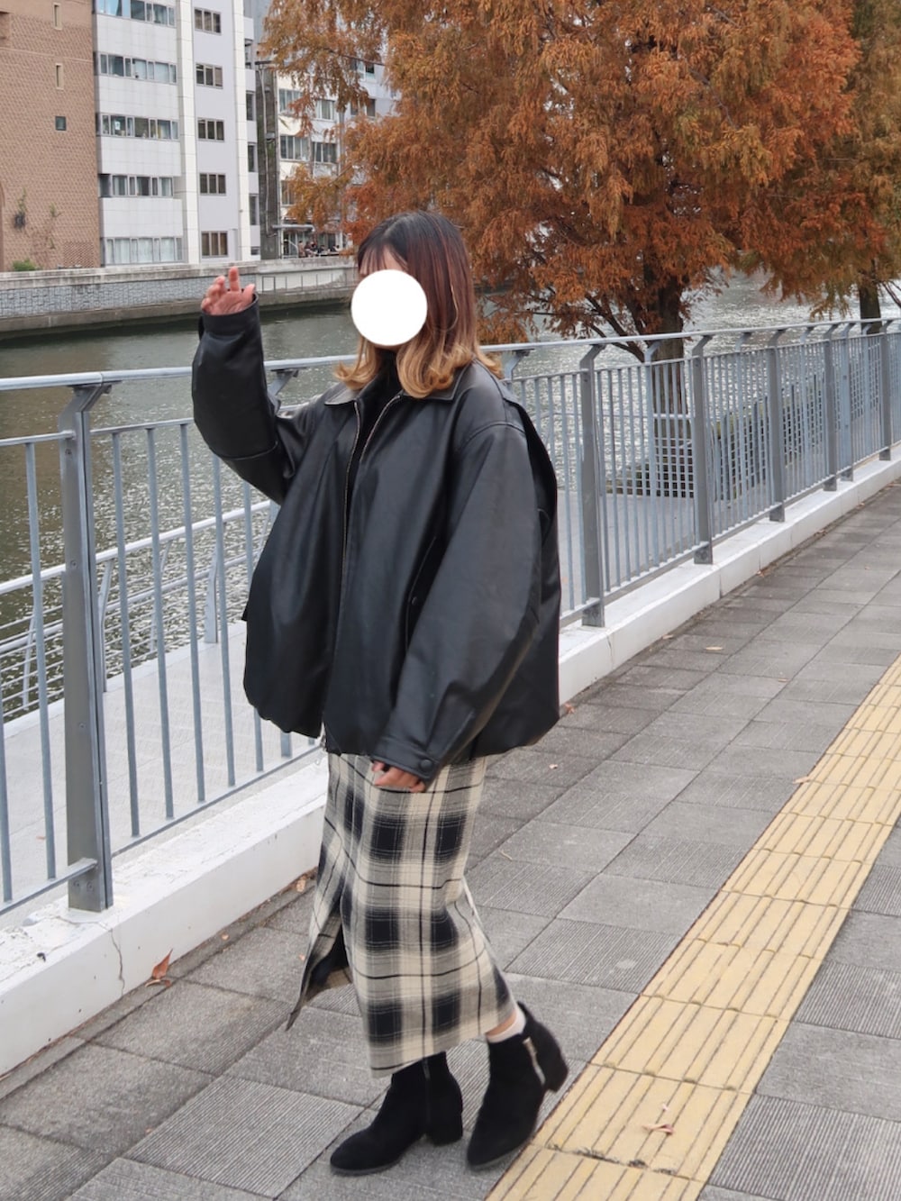 ブラック系のブルゾン、ブラック系のニット/セーター、ベージュ系のスカートを着用したレディースの冬コーディネートの2枚目の写真