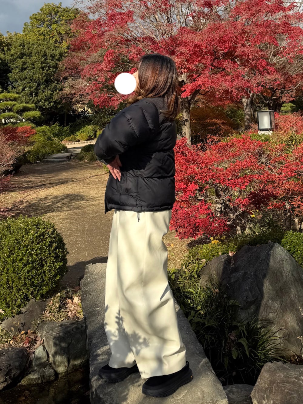 ブラック系のダウンジャケット/コート、グレー系のニット/セーター、ホワイト系のその他パンツを着用したレディースの冬コーディネートの2枚目の写真