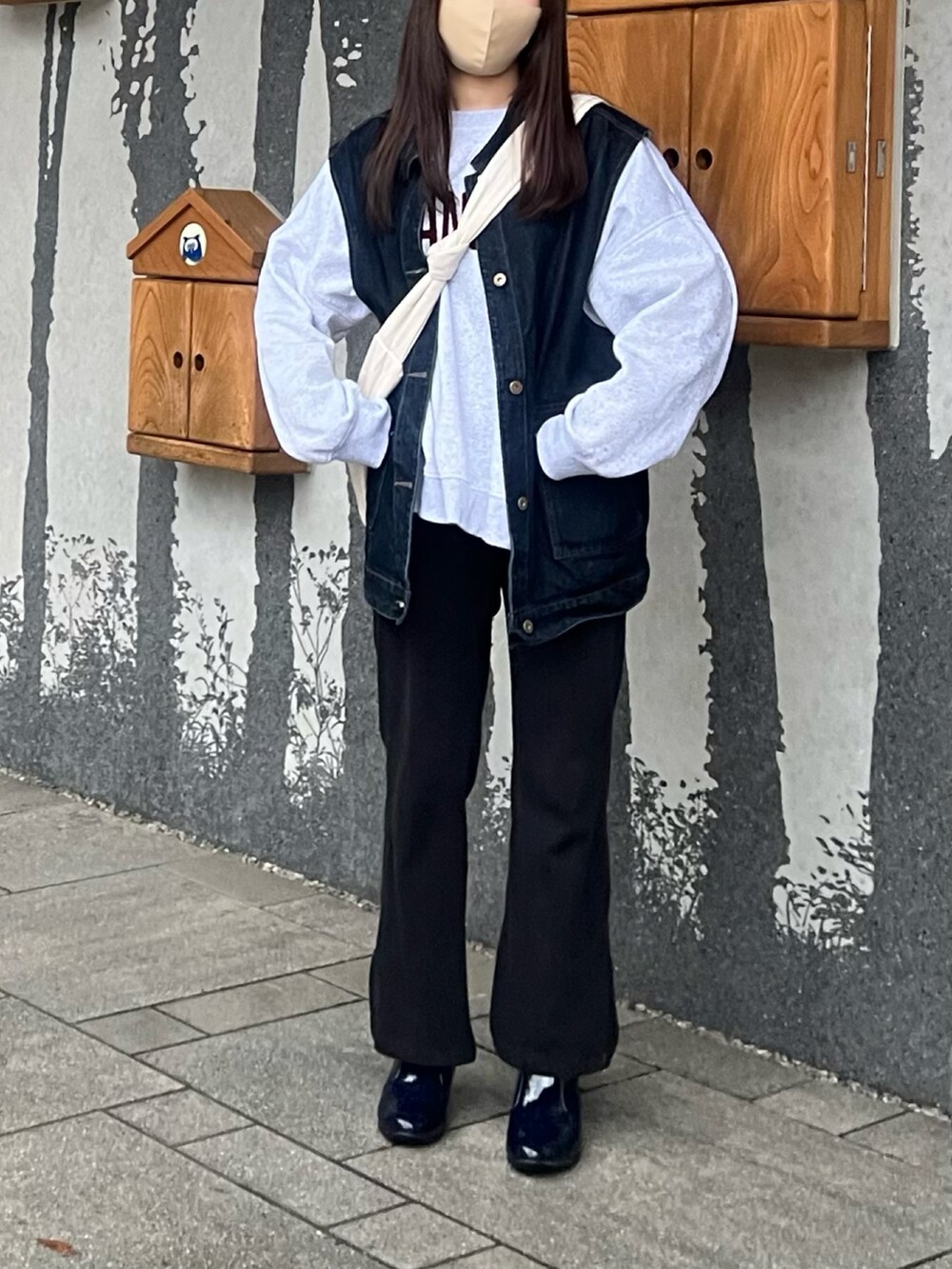 グレー系のスウェット、ブラック系のその他パンツ、ブルー系のベストを着用したレディースの秋コーディネートの2枚目の写真