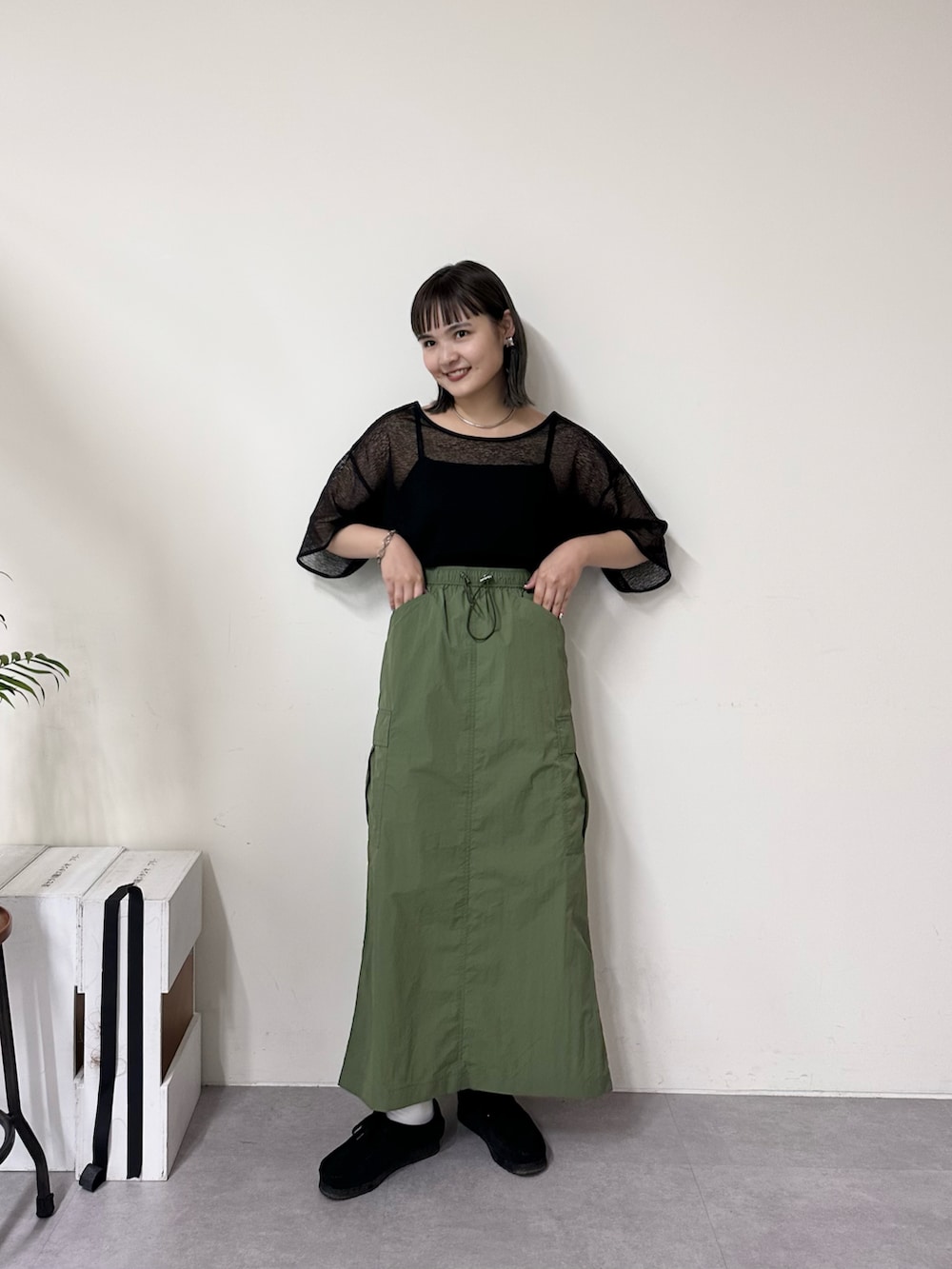 ブラック系のTシャツ/カットソー、グリーン系のスカートを着用したレディースの春コーディネートの2枚目の写真