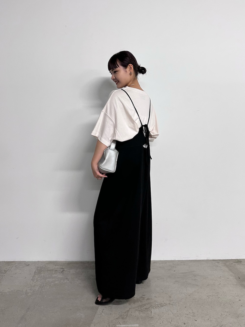 ブラック系のワンピース、ブルー系のTシャツ/カットソー、ブラック系のサンダルを着用したレディースの夏コーディネートの2枚目の写真