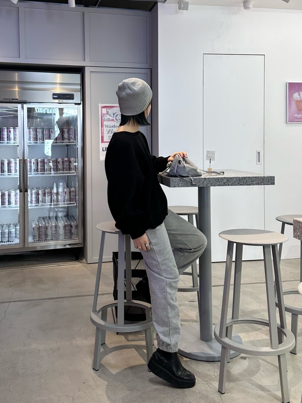 ブラック系のニット/セーター、グレー系のショルダーバッグ、グレー系のニットキャップ/ビーニーを着用したレディースの冬コーディネートの2枚目の写真