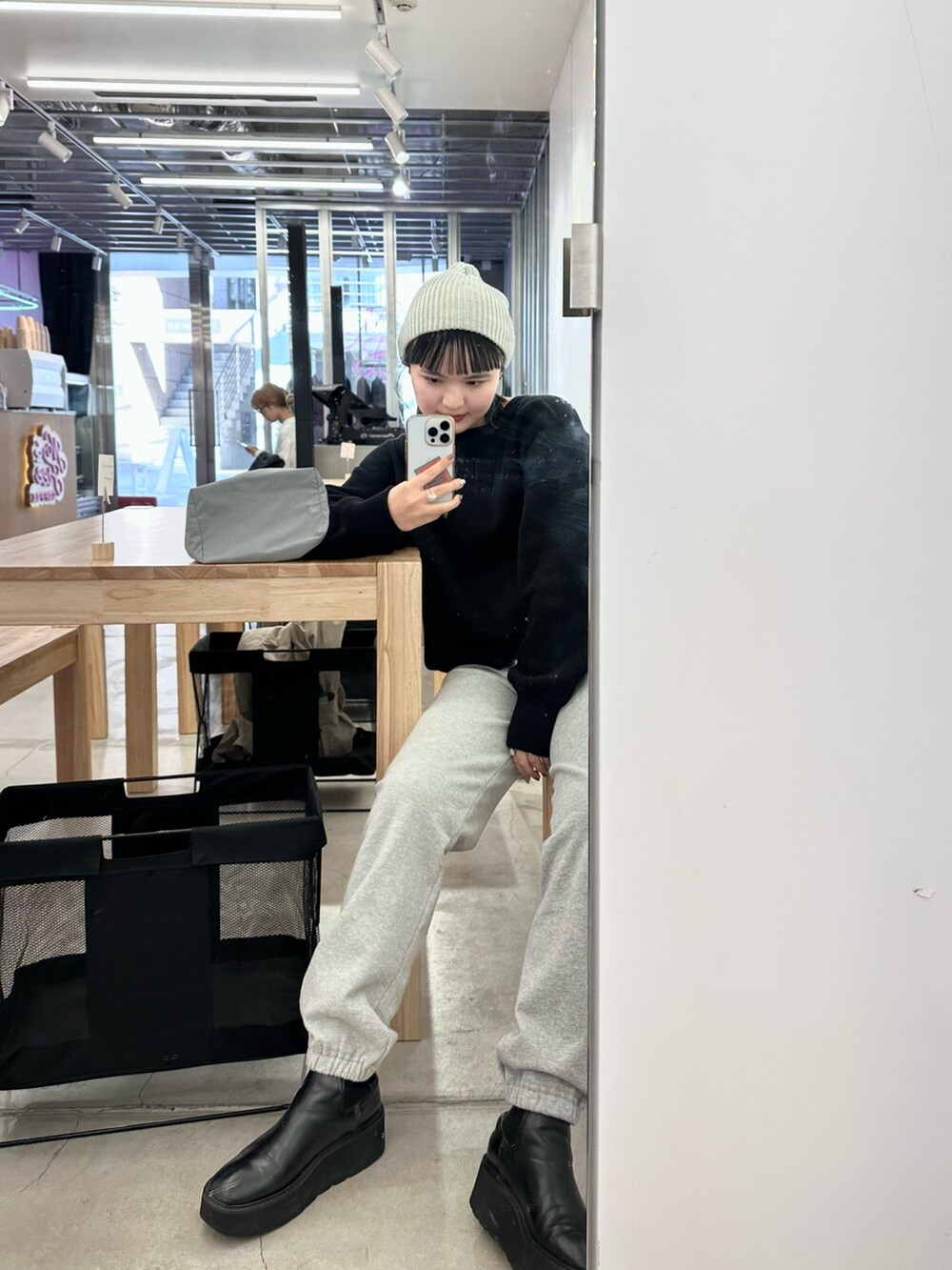 ブラック系のニット/セーター、グレー系のショルダーバッグ、グレー系のニットキャップ/ビーニーを着用したレディースの冬コーディネートの3枚目の写真