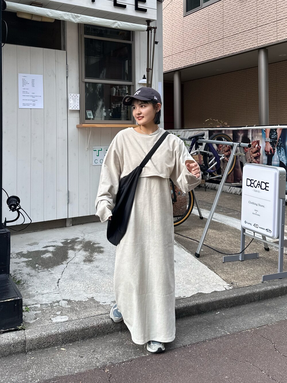 ホワイト系のワンピース、ブラック系のショルダーバッグを着用したレディースの秋コーディネートの2枚目の写真