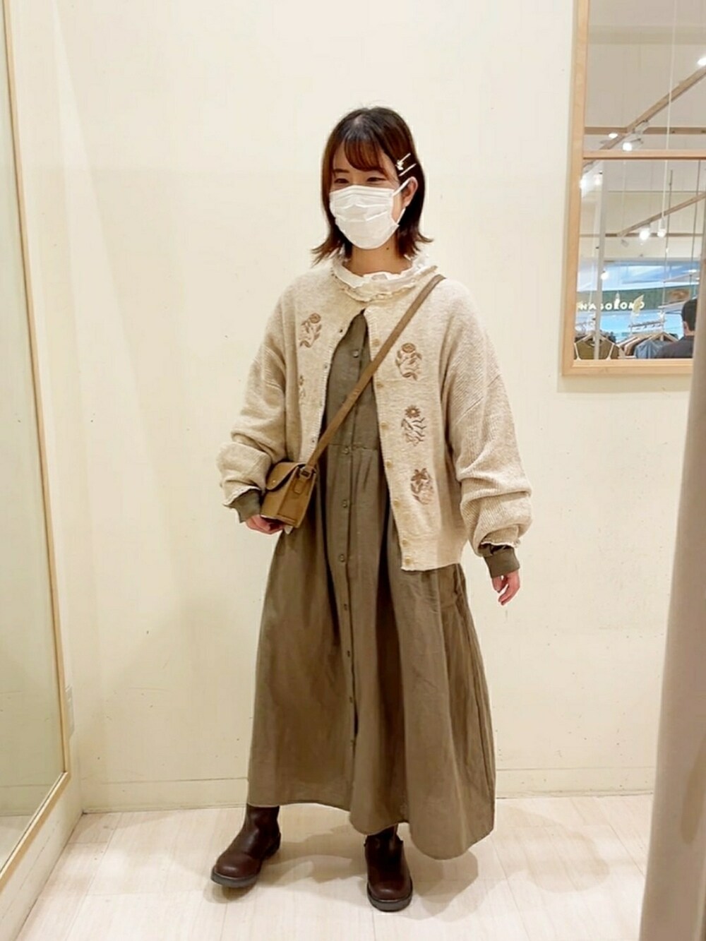 ベージュ系のカーディガン/ボレロ、ホワイト系のシャツ/ブラウス、グリーン系のワンピースを着用したレディースの秋コーディネートの5枚目の写真